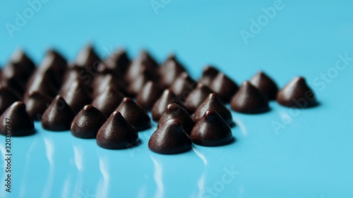 Dark bitter chocolate chips in the shape of drops, for cooking pastry or use in food decor.