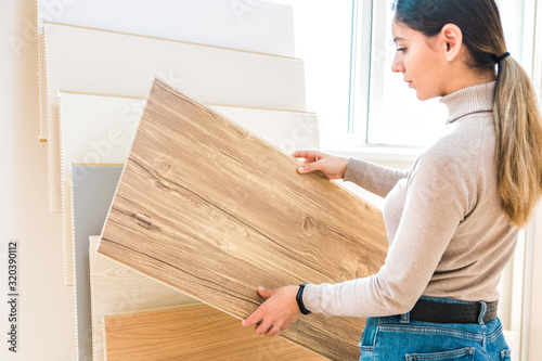 home repair. portrait of woman choosing wood laminated flooring in shop