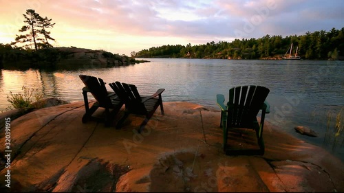 Muskoka chairs on rock beach in cottage country in Georgian Bay, Ontario, Canada