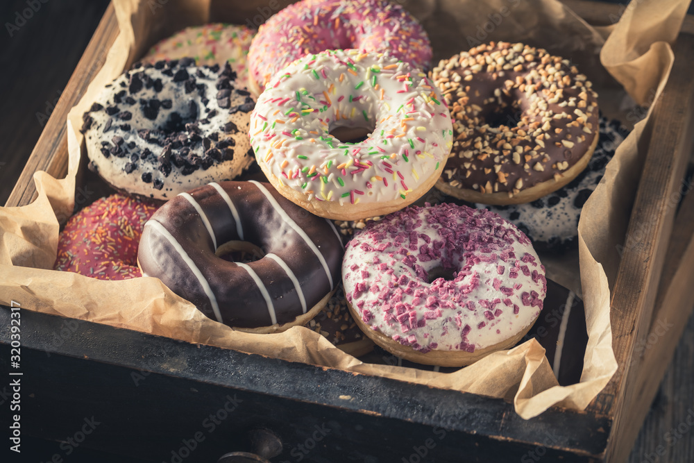 Closeup of tasty donuts in old wooden boxes - obrazy, fototapety, plakaty 