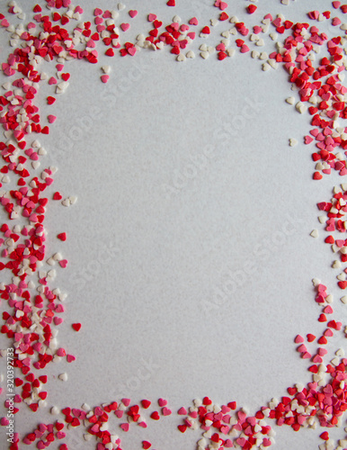 Frame of small colored hearts on a white background