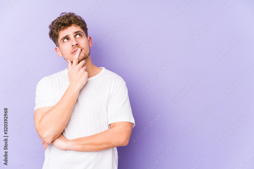 Young blond curly hair caucasian man isolated looking sideways with doubtful and skeptical expression. Young blond curly hair caucasian man isolated looking sideways with doubtful and skeptical expression.