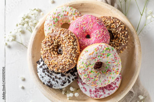 Bild auf Leinwand Homemade donuts with various decoration on white plate