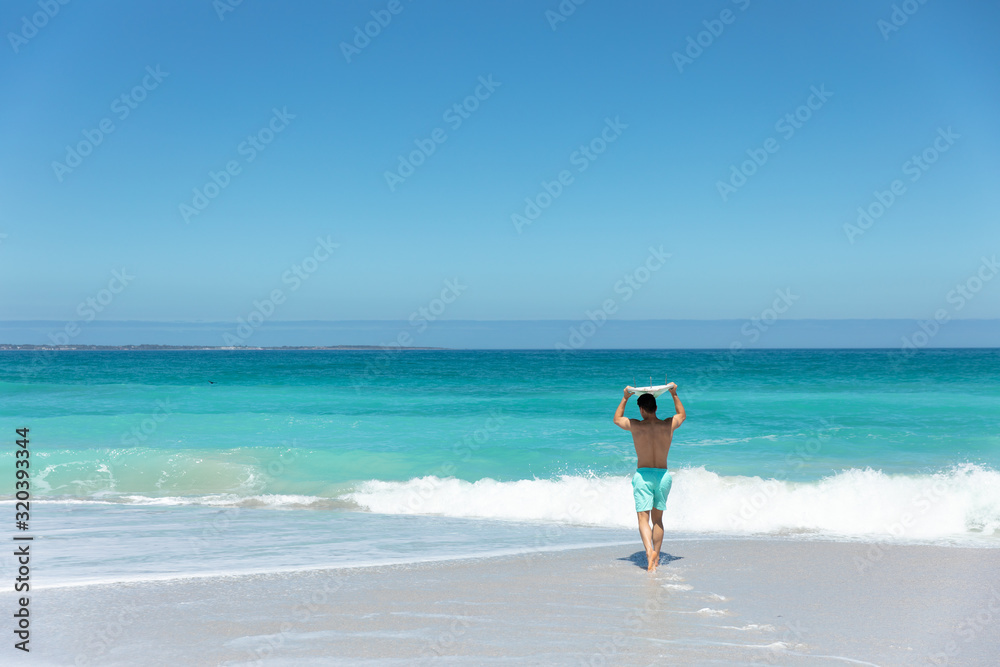 Young man with surfboard at the beach