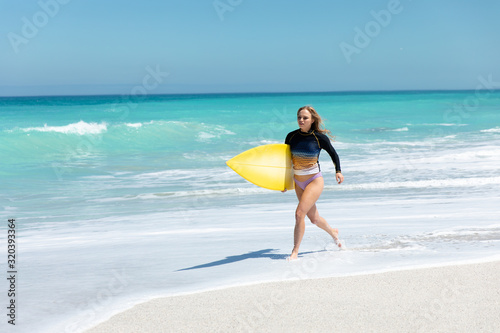 Young woman running with surboard
