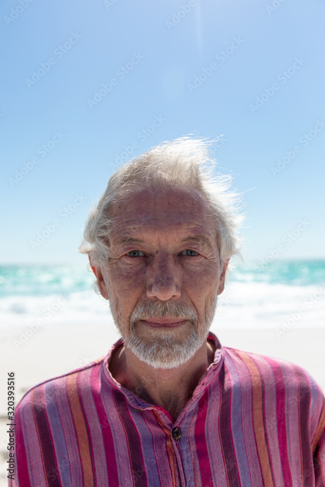 Old man looking at the camera at the beach Old man looking at the camera at the beach