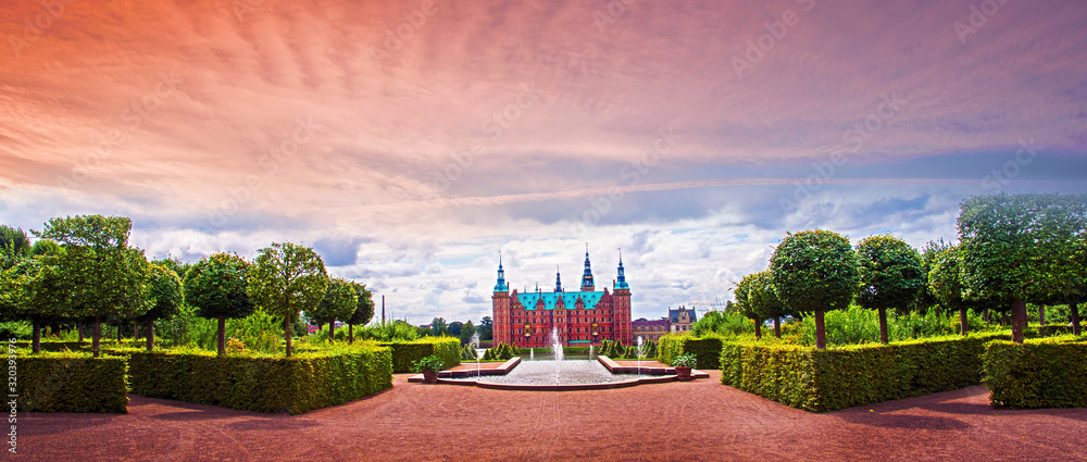 beautiful landscape with fountain and magical incredible gardens and park Frederiksborg slot Castle near Copenhagen. Hillerod, Denmark at sunset. Popular tourist atraction.