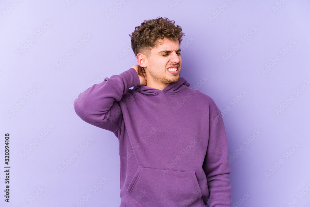 Young blond curly hair caucasian man isolated suffering neck pain due to sedentary lifestyle. Young blond curly hair caucasian man isolated suffering neck pain due to sedentary lifestyle.