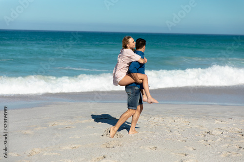 Side view boyfriend carrying girlfriend beach © wavebreak3