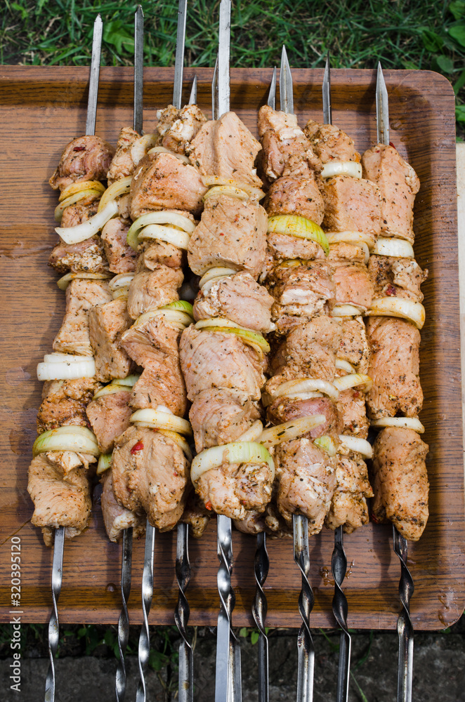 Marinated raw pork skewers with onion rings on skewers. Barbecue With Delicious Grilled Meat.