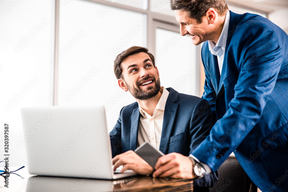 Young office worker smiling at his chief
