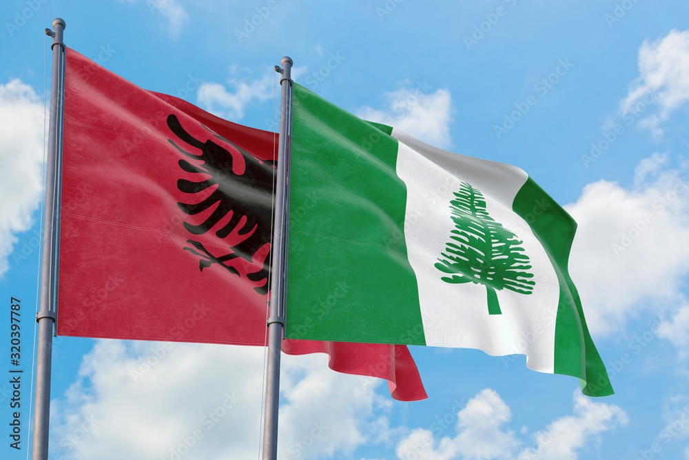 Norfolk Island and Albania flags waving in the wind against white ...