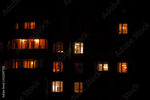 Glowing apartment windows at night where each occupant has his own privacy
