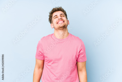 Young blond curly hair caucasian man isolated relaxed and happy laughing, neck stretched showing teeth.