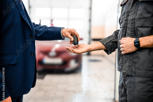 Obraz na płótnie Worker receiving a car key fob from a businessman