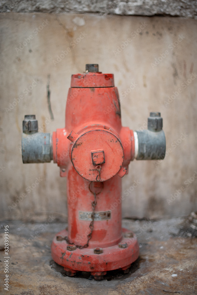 A portrait of an old red fire hydrant seen on the city streets A portrait of an old red fire hydrant seen on the city streets