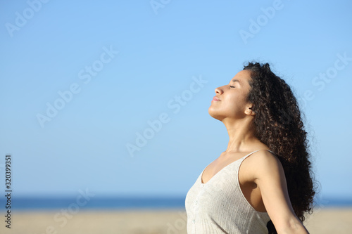 Relaxed latin girl breathing fresh air on the beach