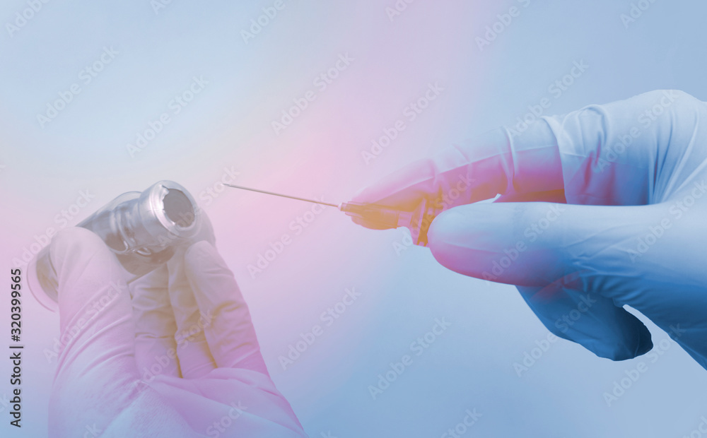 Flu or virus vaccine bottle and syringe in doctor or scientist hands on blue background. Medicine vial dose injection for vaccination or research. Coronavirus 2019-nCoV concept. TSun light effect. Flu or virus vaccine bottle and syringe in doctor or scientist hands on blue background. Medicine vial dose injection for vaccination or research. Coronavirus 2019-nCoV concept. TSun light effect.