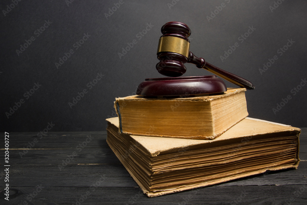 Law concept - Open law book with a wooden judges gavel on table in a courtroom or law enforcement office isolated on white background. Copy space for text Law concept - Open law book with a wooden judges gavel on table in a courtroom or law enforcement office isolated on white background. Copy space for text