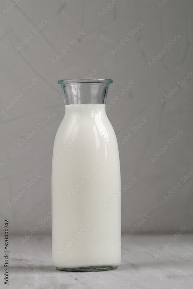 Milk in white glass bottle isolated on grey background, top view and empty space for text Milk in white glass bottle isolated on grey background, top view and empty space for text