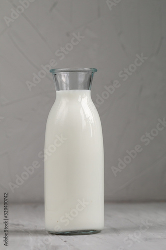 Milk in white glass bottle  isolated on grey background, top view and empty space for text