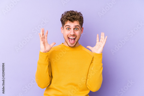 Принти на полотні Young blond curly hair caucasian man isolated celebrating a victory or success, he is surprised and shocked