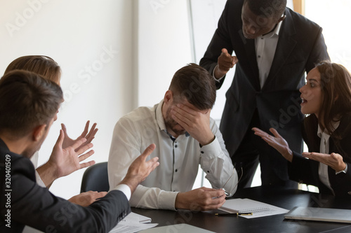 Frustrated employee feels stressed suffers from hostile coworkers photo