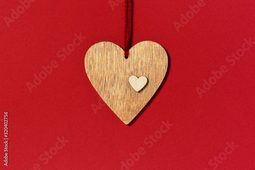 Wooden heart on the red background, composition for Valentines day