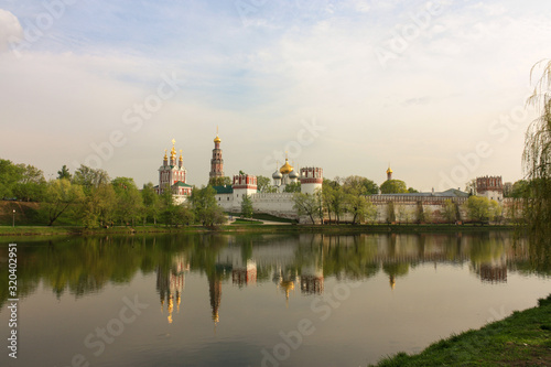 Novodevichy monastery in sunny weather with reflections in summer evening, Moscow, Russia