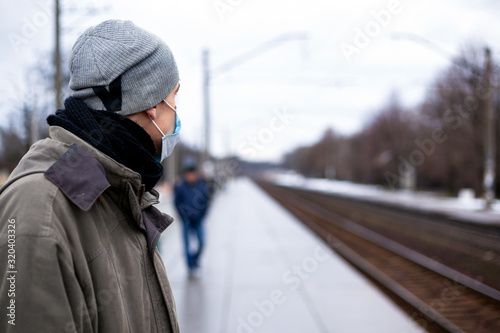 the guy in the respirator is waiting for the train. Concept: colds, flu, coronavirus