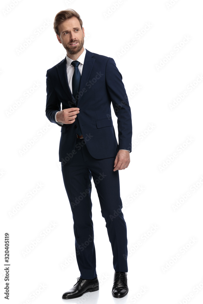 sexy young businessman looking to side and adjusting coat sexy young businessman looking to side and adjusting coat
