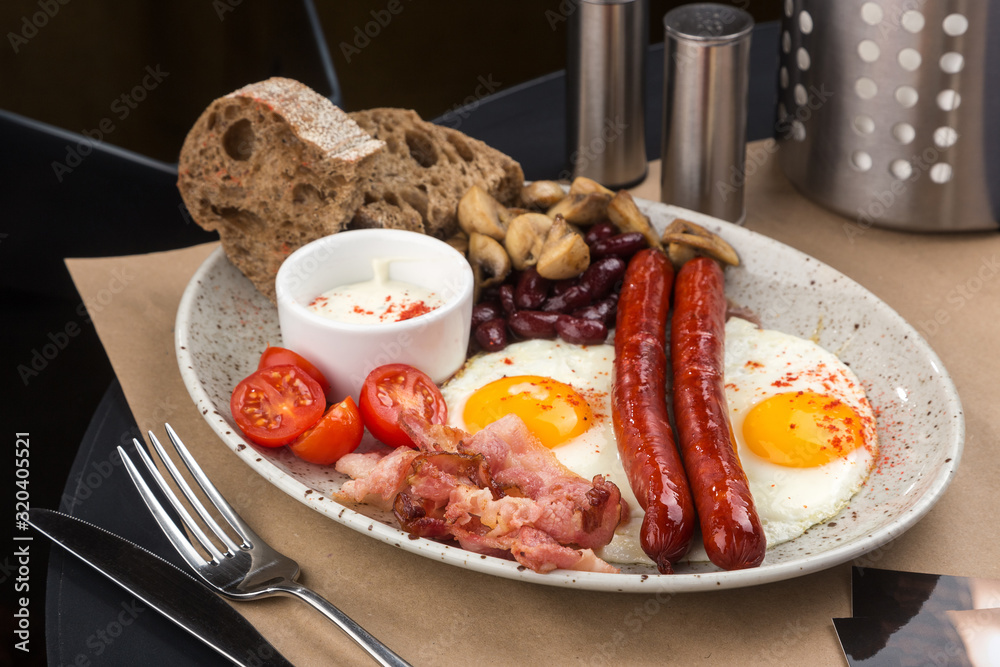 Homemade delicious american breakfast with sunny side up fried egg, toast, sausage, fruits, vegetable, strawberry jam, croissant Homemade delicious american breakfast with sunny side up fried egg, toast, sausage, fruits, vegetable, strawberry jam, croissant