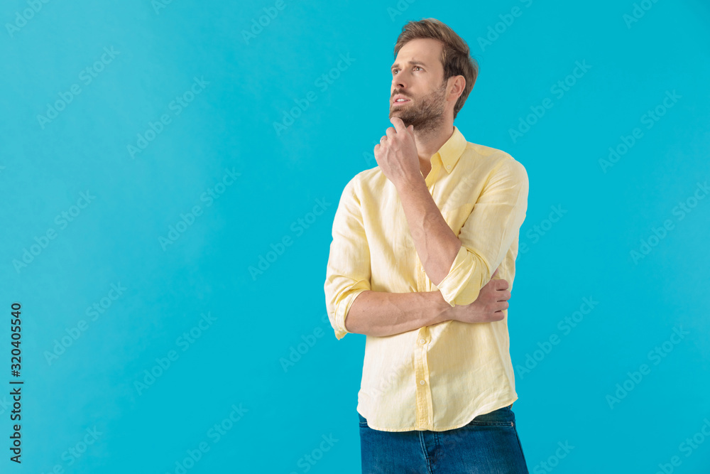 Wondering casual holding his hand on his chin and thinking Wondering casual holding his hand on his chin and thinking