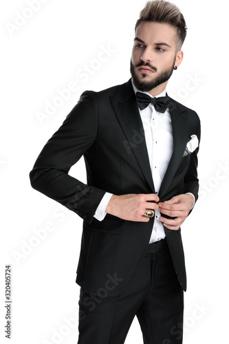 businessman standing and fixing jacket while looking aside cool photo