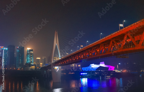 Night view of Chongqing city.  View of the bridge over the river.  Lighting and office buildings.  River reflections and lights.  Cityscape