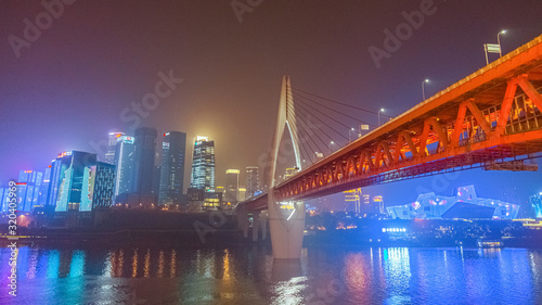 Night view of Chongqing city.  View of the bridge over the river.  Lighting and office buildings.  River reflections and lights.  Cityscape © ChuanSheng