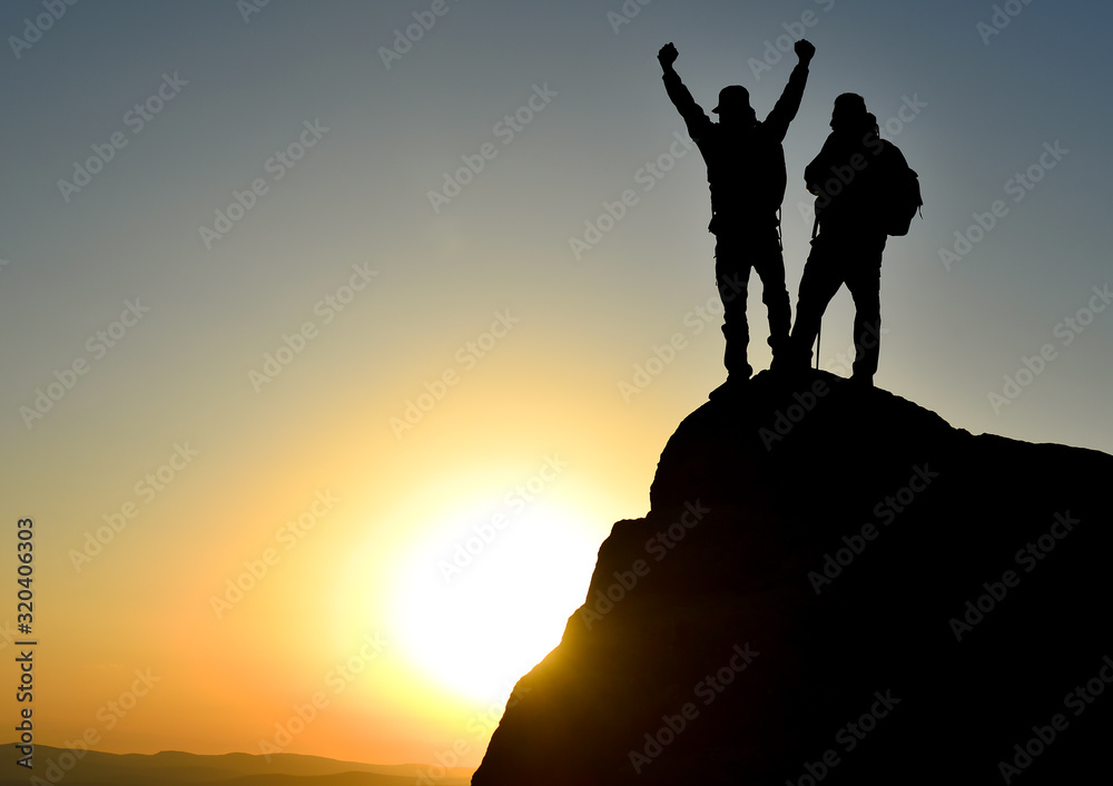 two successful people observe the environment from the summit and enjoy amazing views