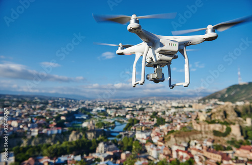 drone with digital camera hovering over city