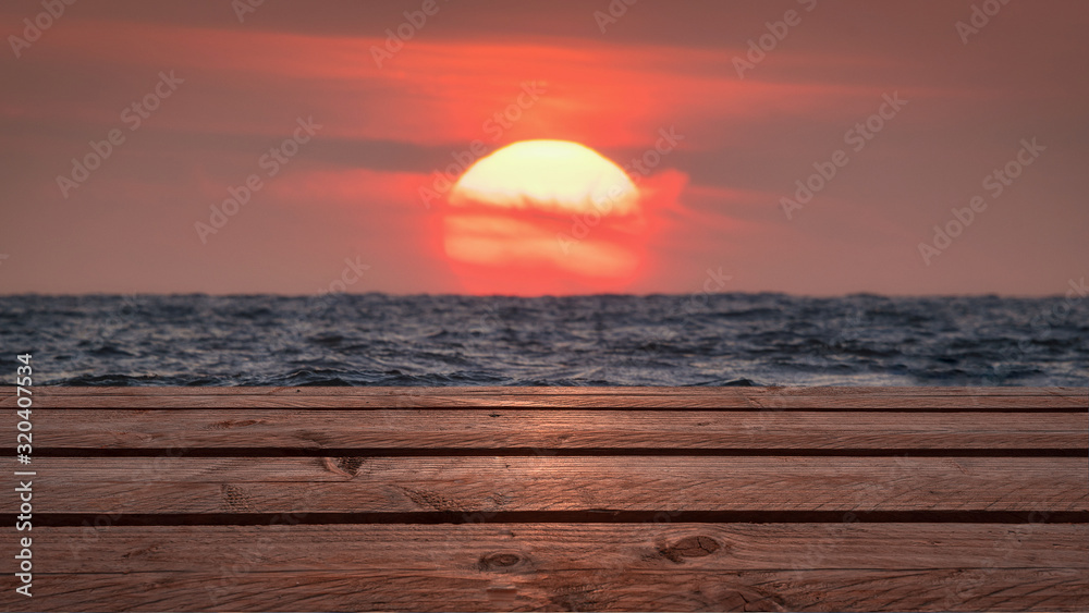 Steg mit Sonnenuntergand über dem Meer im Hintergrund