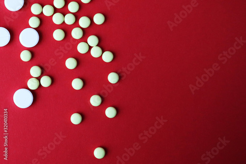 Pills on red background. Top view with copy space. Medicine concept. © Zhanna