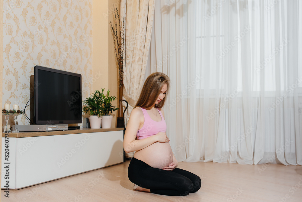 A pregnant girl does yoga at home. Health A pregnant girl does yoga at home. Health