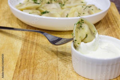 Traditional Russian hand-made dumplings with butter, herbs and sour cream.