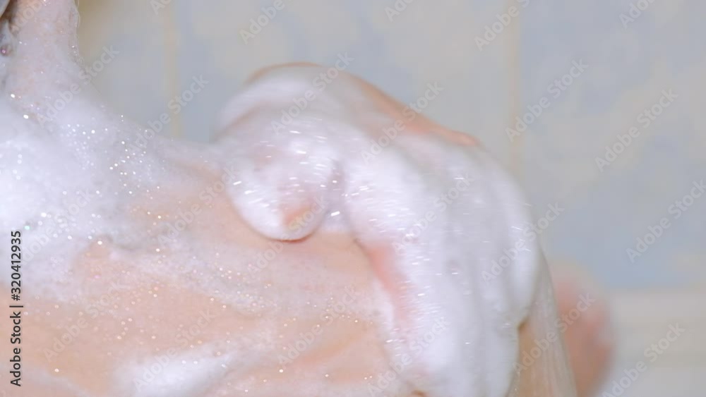 Woman washes shower soap foam, slow movement hand on shoulder close-up Woman washes shower soap foam, slow movement hand on shoulder close-up