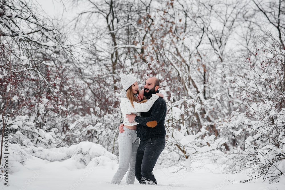 Couple playing with snow in the forest