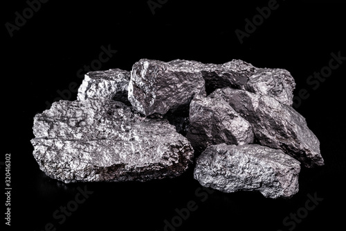 large silver nugget on black background. Raw silver stone, silver nugget native to Liberia, isolated on black background. Mineral extraction.