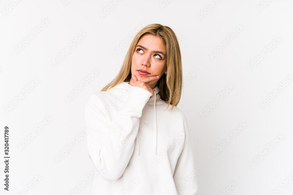 Young blonde caucasian woman isolated thinking and looking up, being reflective, contemplating, having a fantasy. Young blonde caucasian woman isolated thinking and looking up, being reflective, contemplating, having a fantasy.