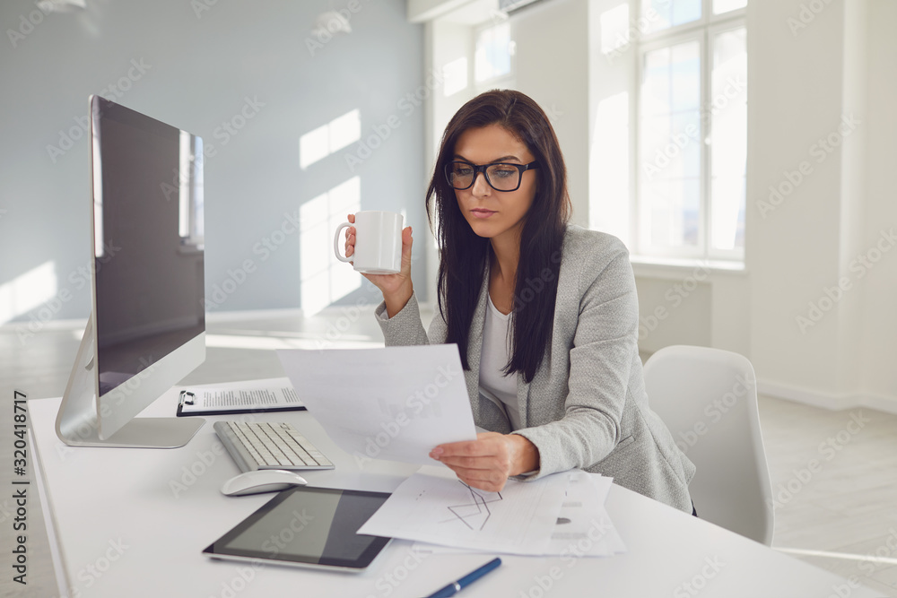 Business woman in glasses confident sitting at a table in the workplace in the office Business woman in glasses confident sitting at a table in the workplace in the office