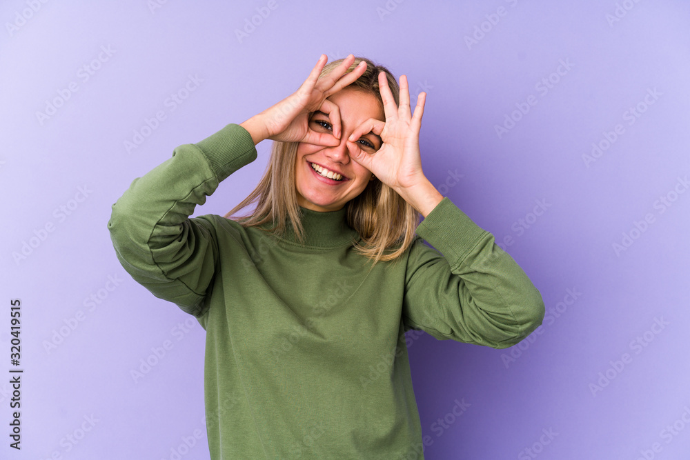 Young blonde caucasian woman isolated showing okay sign over eyes Young blonde caucasian woman isolated showing okay sign over eyes