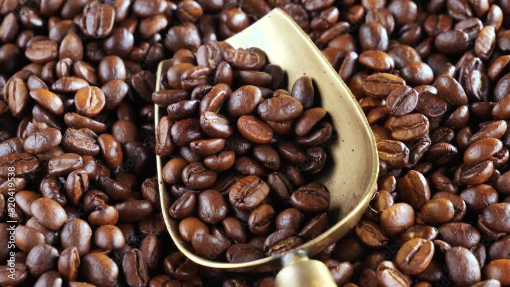 Coffee beans are fried in a pan and mixed with a spoon Coffee beans are fried in a pan and mixed with a spoon