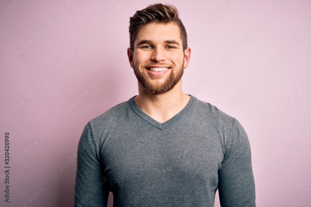 Young handsome blond man with beard and blue eyes wearing casual sweater with a happy and cool smile on face. Lucky person. Young handsome blond man with beard and blue eyes wearing casual sweater with a happy and cool smile on face. Lucky person.